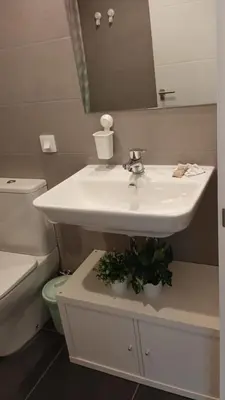 a bathroom with a sink and a toilet and a mirror at Contemporary 2BR with Pool & Gym in Hospitalet de Llobregat