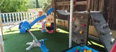 an outdoor playground with a slide and a swing at Brad House in Can Trabal