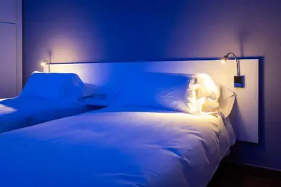 a blue room with a bed with a teddy bear on it at Hotel La Sagrera in Sant Fruitos de Bages