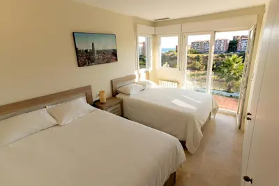 two beds in a room with a window at Beachy House - Casa en Montgat, Barcelona in Montgat