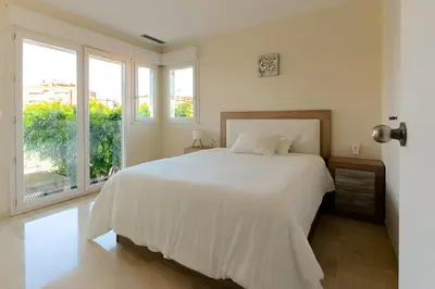 a white bed in a room with windows at Beachy House - Casa en Montgat, Barcelona in Montgat