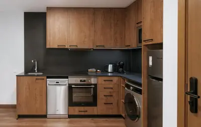 a kitchen with wooden cabinets and a stove top oven at Apartaments Casa Padró in Manresa