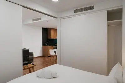 a bedroom with a white bed and a television at Apartaments Casa Padró in Manresa