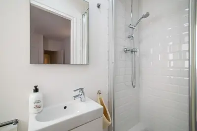 a white bathroom with a sink and a shower at Sunset Beachfront in Sitges in Sitges