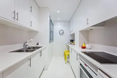 a white kitchen with white cabinets and a sink at Sweett - Calabria in Barcelona