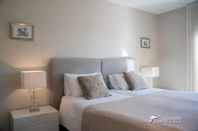two beds in a room with a window at Villa Valentino Modern Villa with heated pool in Olivella