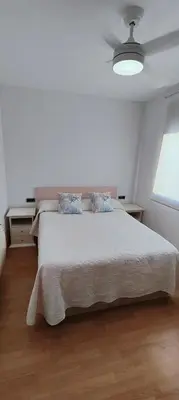 a white bedroom with a bed and a window at Vilanova Beach Stay in Vilanova i la Geltrú