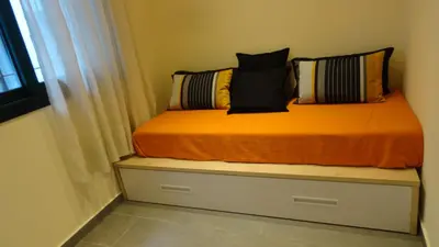 a bed with pillows sitting on top of a drawer at Apartamento zona playa de San Sebastian in Sitges