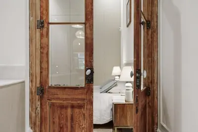 a white bedroom with a bed and a mirror at Reus - 1 bedroom in Ciutat Vella in Barcelona