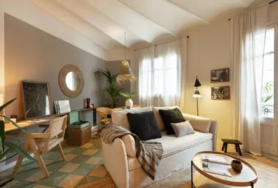 a living room with a couch and a table at Bawah - 2 bedrooms in Eixample Esquerra in Barcelona