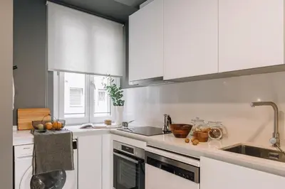 a kitchen with white cabinets and a sink at Tauca - 2 bedrooms and office in Eixample Dreta in Barcelona