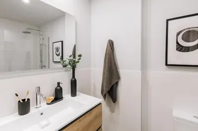 a white bathroom with a sink and a mirror at Tauca - 2 bedrooms and office in Eixample Dreta in Barcelona