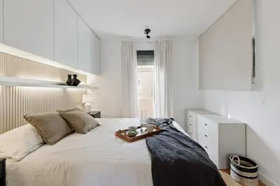 a white bedroom with a bed and a mirror at Celoni - 1 bedroom and office in Sagrada Família in Barcelona