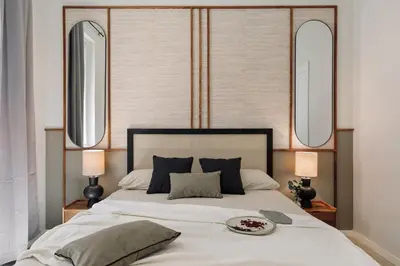 a bedroom with a large white bed with two mirrors at Paleo - 2 bedrooms and office in Eixample Dreta in Barcelona