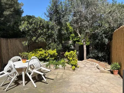 two white chairs and a table in a garden at Can Bosquet - Casa de invitados adosada a casa familiar in Corbera de Llobregat