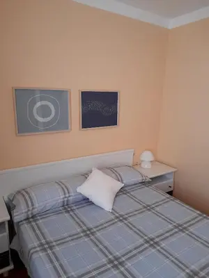 a small bedroom with a bed and a desk at Canet playa in Canet de Mar