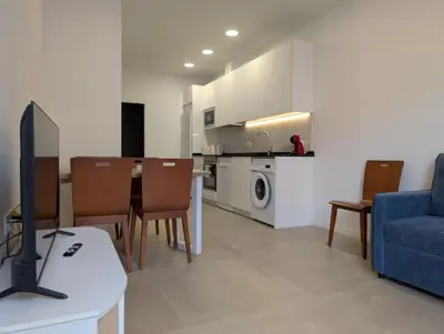 a kitchen and living room with a table and chairs at Cal Ticó, 6 guests Monistrol de Montserrat in Monistrol