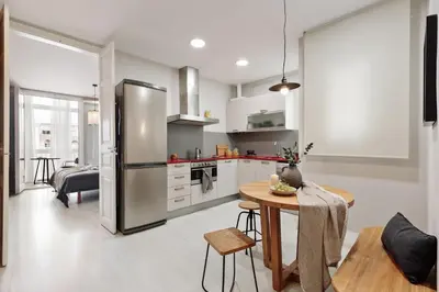 a kitchen with a table and a refrigerator at Judd - 3 bedrooms and balcony in Eixample Esquerra in Barcelona