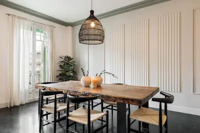 a kitchen with white cabinets and a table and chairs at Valls - 2 bedrooms and office in Gràcia in Barcelona