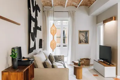 a hallway with a chair and a lamp and a window at Senahu - 2 bedrooms and office in Eixample Dreta in Barcelona
