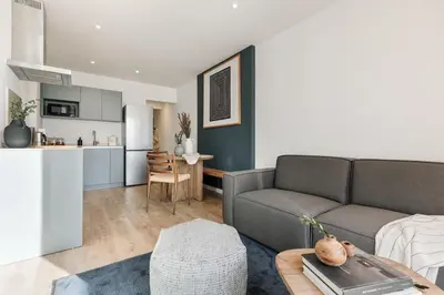 a living room with a couch and a kitchen at Banchina - 1 bedroom and terrace in Sant Gervasi in Barcelona