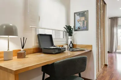a wooden desk under a window with a window sill at Nerano - 2 bedrooms and terrace in Gràcia in Barcelona