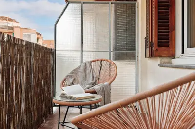 a chair with a book on it on a balcony at Levent - 3 bedrooms and terrace in Sant Antoni in Barcelona