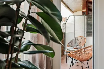 a room with a chair and a table and a plant at Levent - 3 bedrooms and terrace in Sant Antoni in Barcelona