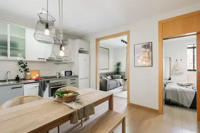 a kitchen with white cabinets and a table with a basket of fruit at Furore - 1 bedroom in Eixample Esquerra in Barcelona
