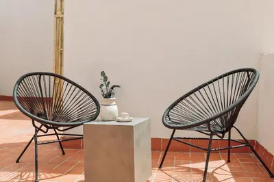 two chairs sitting next to a table with a vase at Cava - 2 bedrooms and terrace in Ciutat Vella in Barcelona
