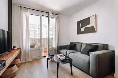 a living room with a couch and a tv at Lescun - 2 bedrooms in Eixample Esquerra in Barcelona