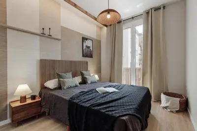 a living room with a table and a chair and a tv at Atitlan - 3 bedrooms, office and balcony in Eixample Esquerra in Barcelona