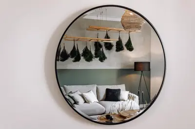 a mirror reflecting a living room with a white couch at Baeza - 2 bedrooms and office in Eixample Esquerra in Barcelona
