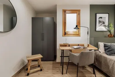 a kitchen with white cabinets and a wooden table at Potosi - 3 bedrooms and balcony in Eixample Dreta in Barcelona