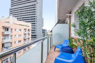 a balcony with blue chairs and some buildings at Modern Penthouse with Large Terrace in Poblenou Perfect for Holidays or Work Close to the Beach and Public Transport in Barcelona