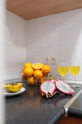 two slices of fruit on a counter with two glasses of wine at Cozy and Modern Apartment in Poblenou 3 Bedrooms Perfect for 4 Guests in Barcelona