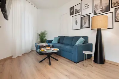a living room with a blue couch and a table at Cozy and Modern Apartment in Poblenou 3 Bedrooms Perfect for 4 Guests in Barcelona