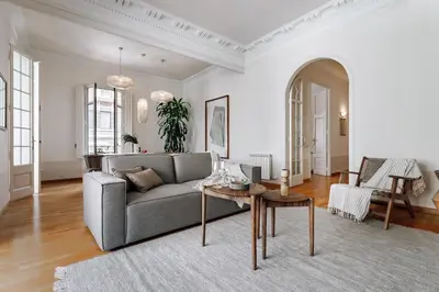 a bedroom with a large bed and a chair at Vico - 4 bedrooms and office in Eixample Dreta in Barcelona