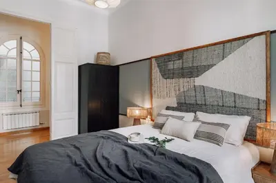a bedroom with a bed and a living room at Vico - 4 bedrooms and office in Eixample Dreta in Barcelona