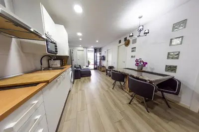 a kitchen with a counter and a table and chairs at Terrace & BEACH apartment in Calella