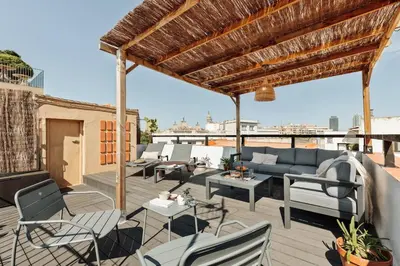 a patio with chairs and a couch on a roof at Atuh - Studio and terrace in El Born in Barcelona