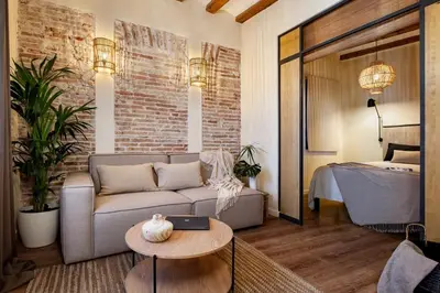 a bedroom with a bed and a couch in a room at Atuh - Studio and terrace in El Born in Barcelona