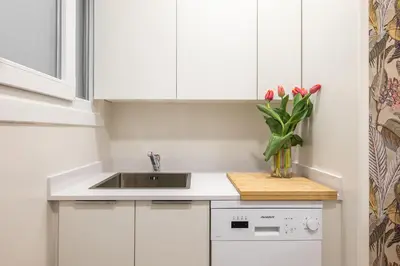 a dining room with a table and chairs and a bedroom at Acogedor Apartamento Centro , Cerca de Plaza España y Barcelona in Hospitalet de Llobregat