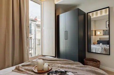 a kitchen with a wooden table and a kitchen with white cabinets at Kevran - 2 bedrooms and terrace in Sant Pere in Barcelona