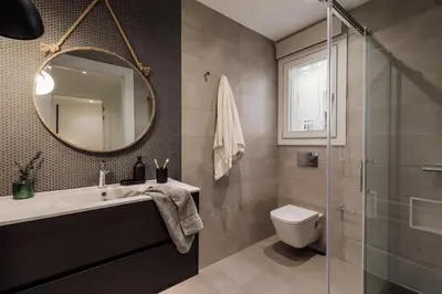 a bathroom with a sink and a toilet and a mirror at Fener - 3 bedrooms in La Dreta de l'Eixample in Barcelona