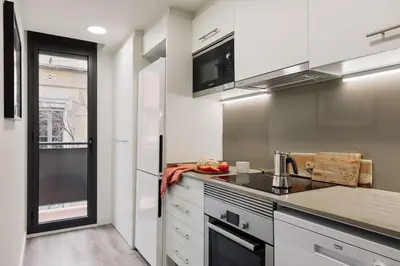 a living room with a couch and a tv at Falco - 2 bedrooms with shared pool in Les Corts in Barcelona
