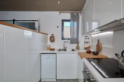 a white kitchen with a sink and a stove at Aoraki - Penthouse and terraces in Eixample Dreta in Barcelona