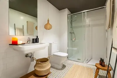 a bedroom with a bed and a mirror and a stool at Chalby - 4 bedrooms in Eixample Esquerra in Barcelona