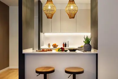 a kitchen with two stools and two lights at Isilf - 2 bedrooms and balcony in Sant Gervasi in Barcelona