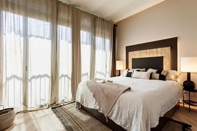 a bedroom with a large bed and large windows at Nubian - 2 bedrooms in Eixample Dreta in Barcelona